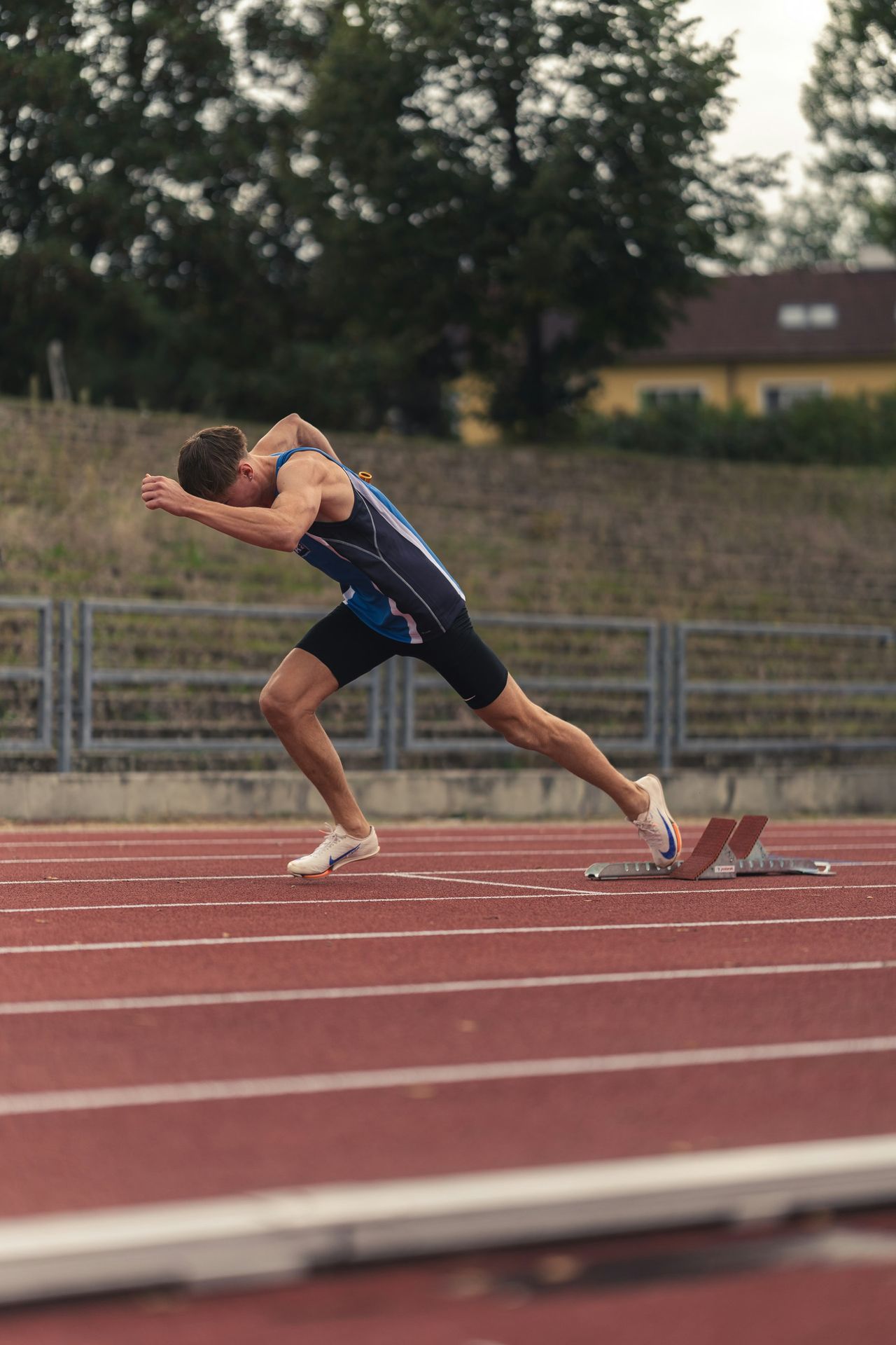 A male runner starting a race on a track.